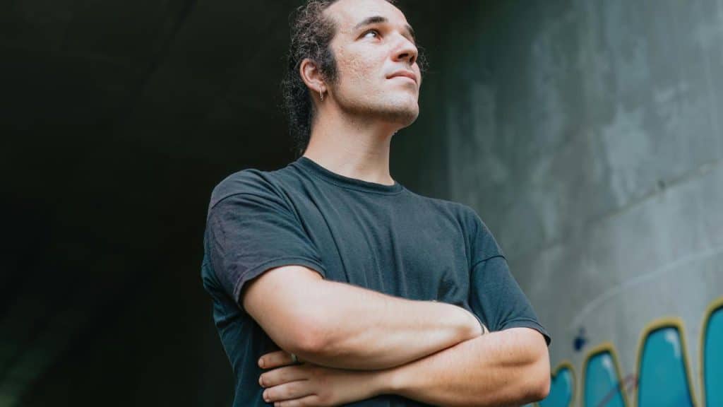 A man standing with folded arms and looking upward.