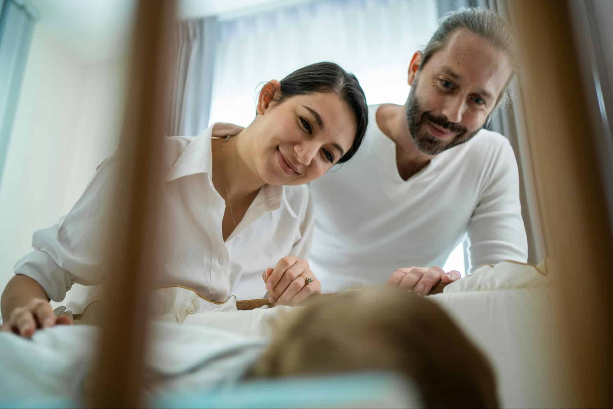 A man and woman looking at their baby