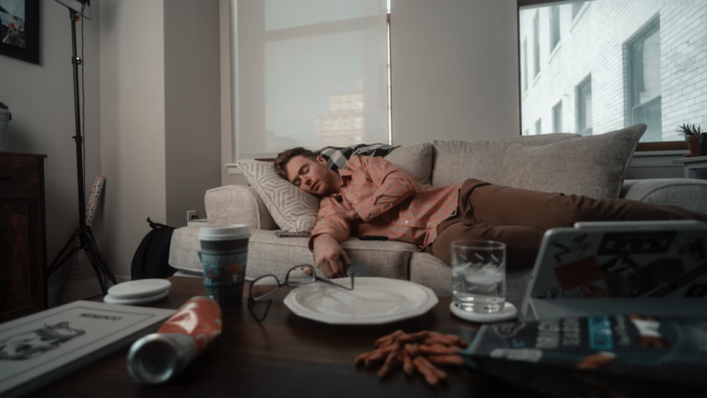 A man sleeping on the couch instead of working