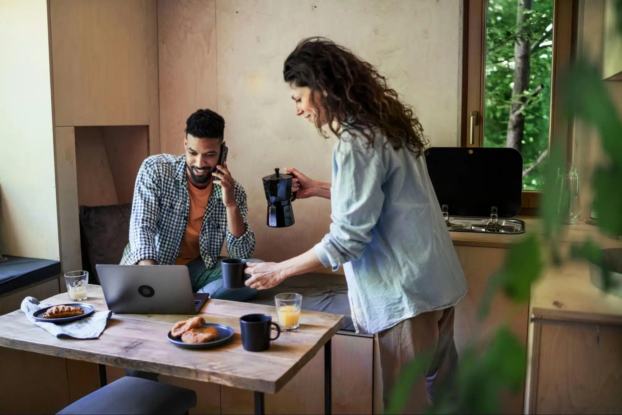 A man working and a woman preparing breakfast
