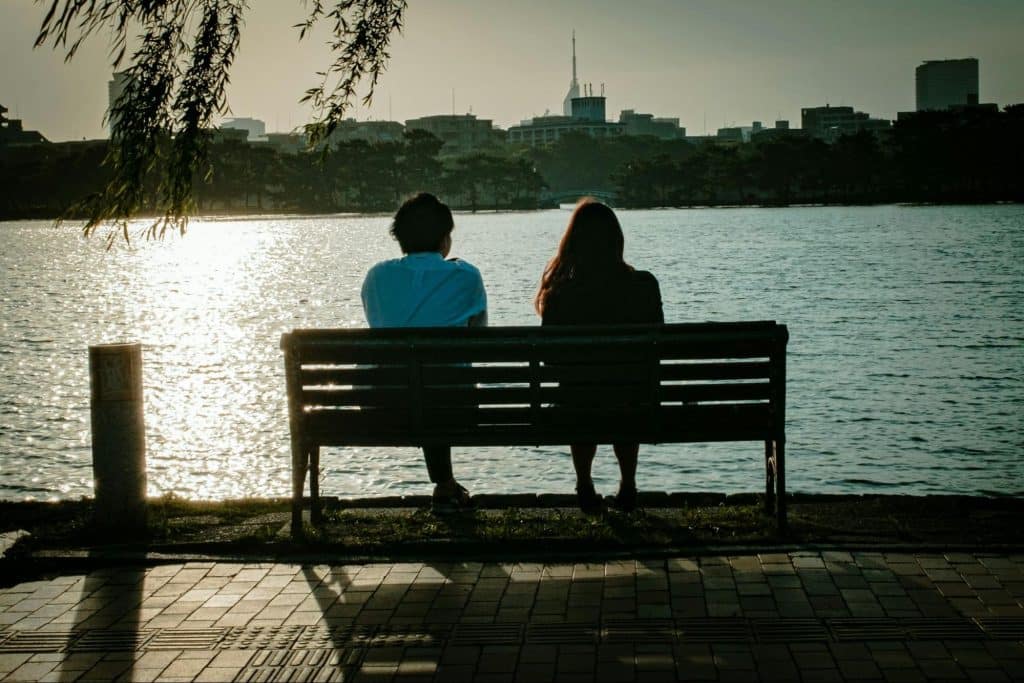 A man and woman sitting at the bench