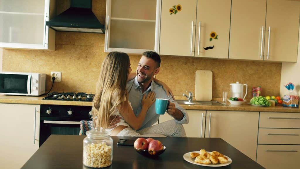 A couple cuddling in the kitchen