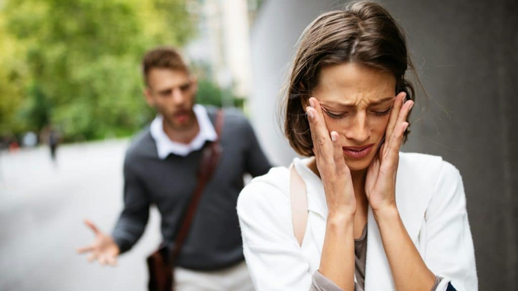 A man screaming at his girlfriend outdoors.