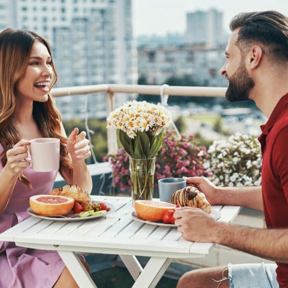 A couple enjoying a meal on a rooftop.