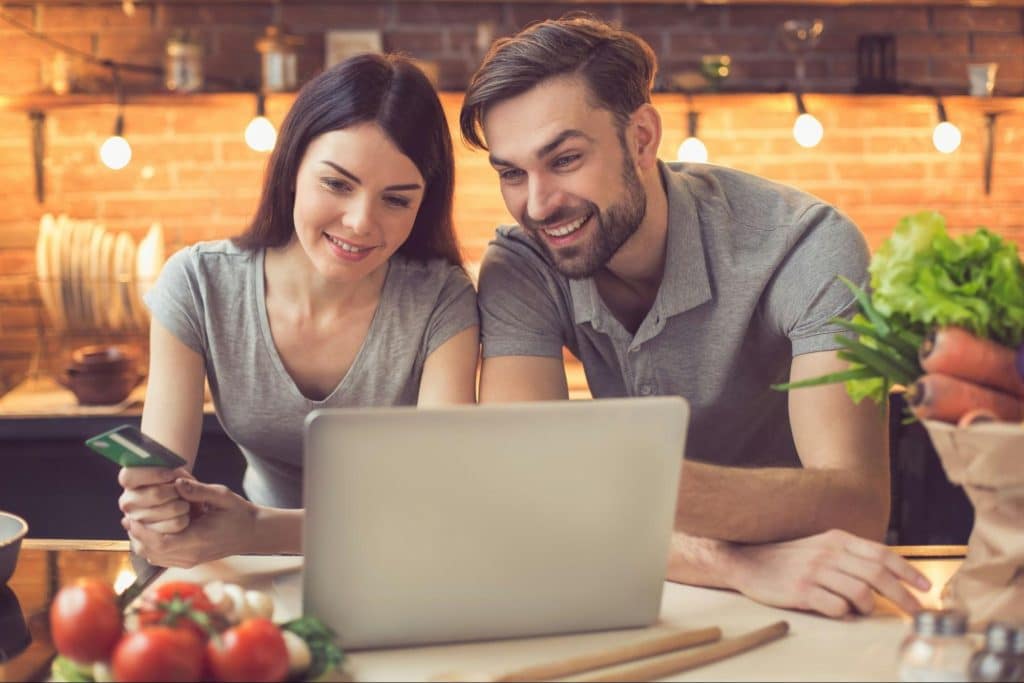 A man and woman looking at the laptop 