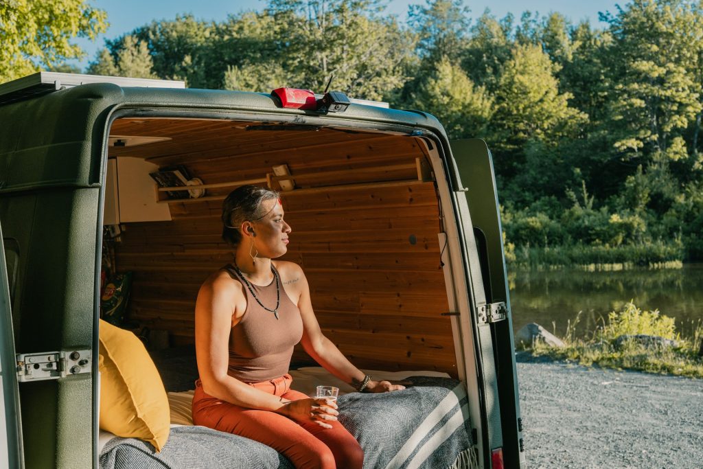 A woman sitting at the back of a green truck.