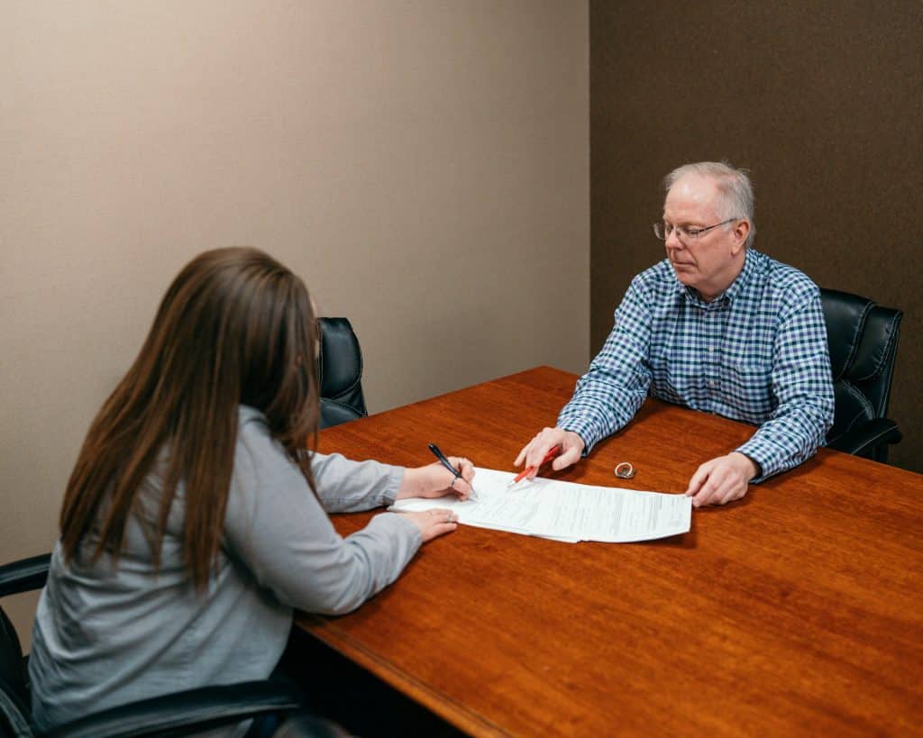 A woman signing papers.