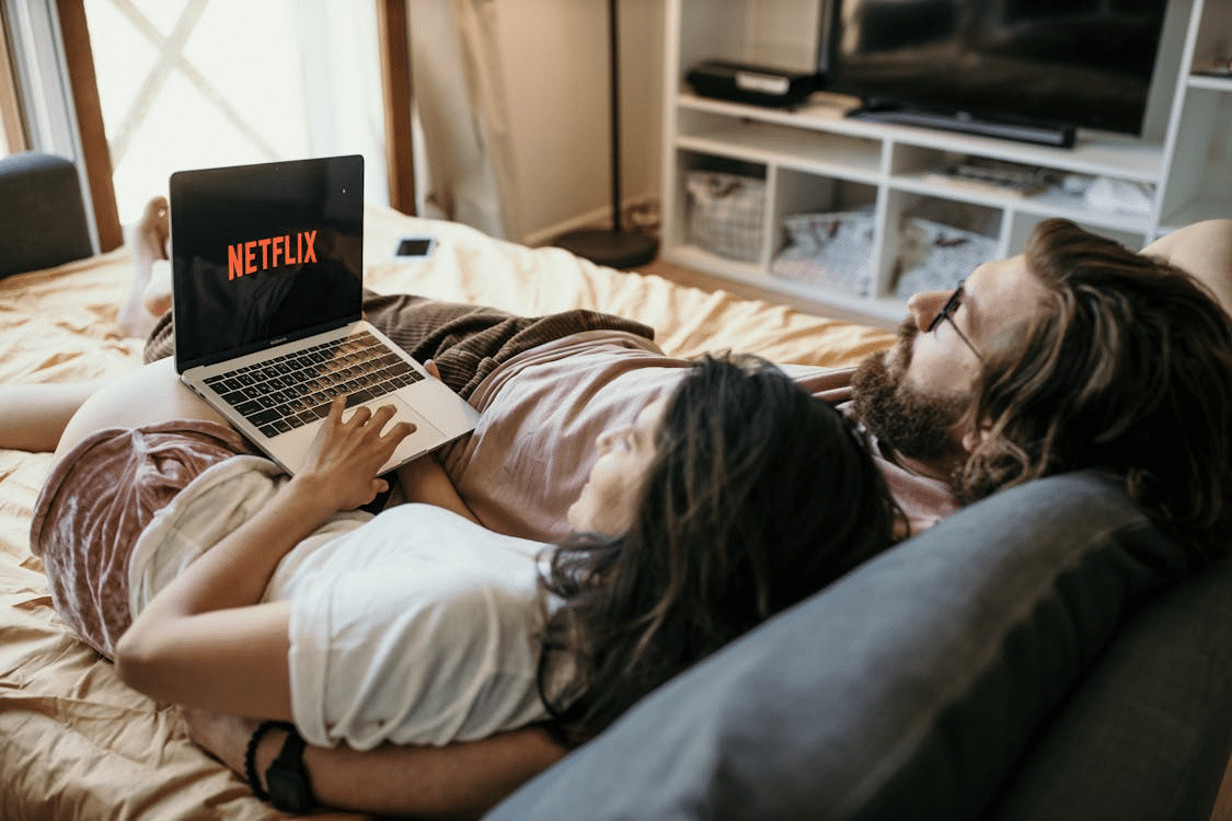 A couple watching a movie on the bed