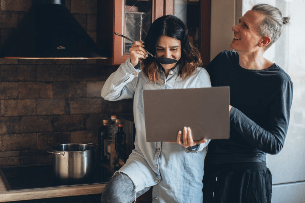 A man and a woman laughing in the kitchen
