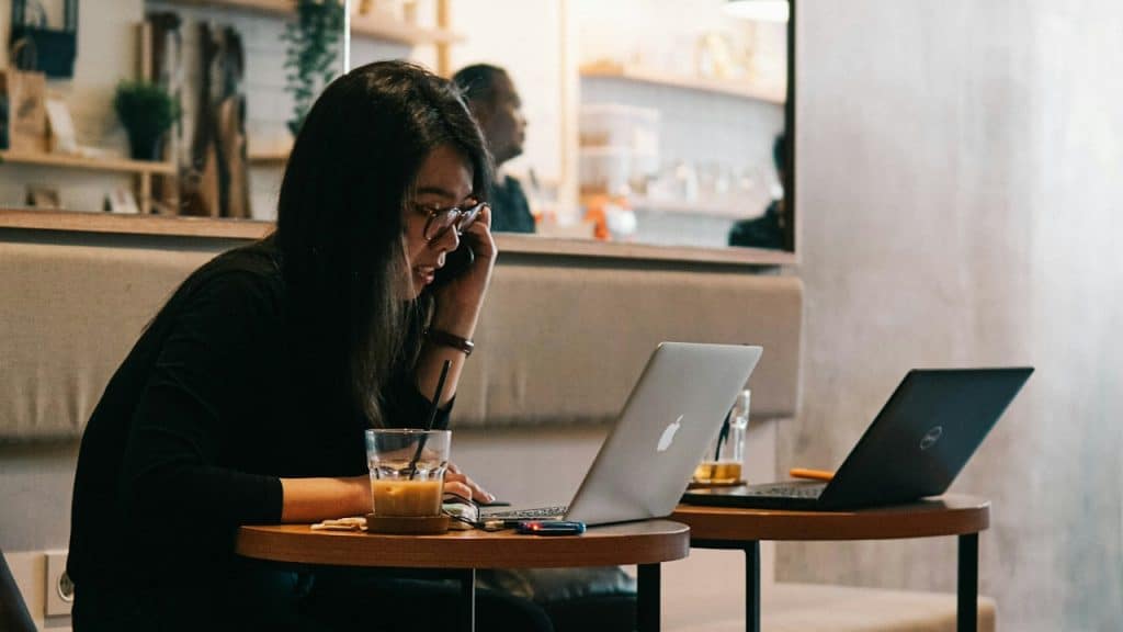 A woman in a black long-sleeve shirt using a MacBook.