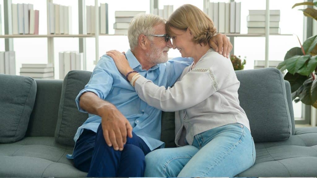 Happy Caucasian senior couple relaxing in living room at home.