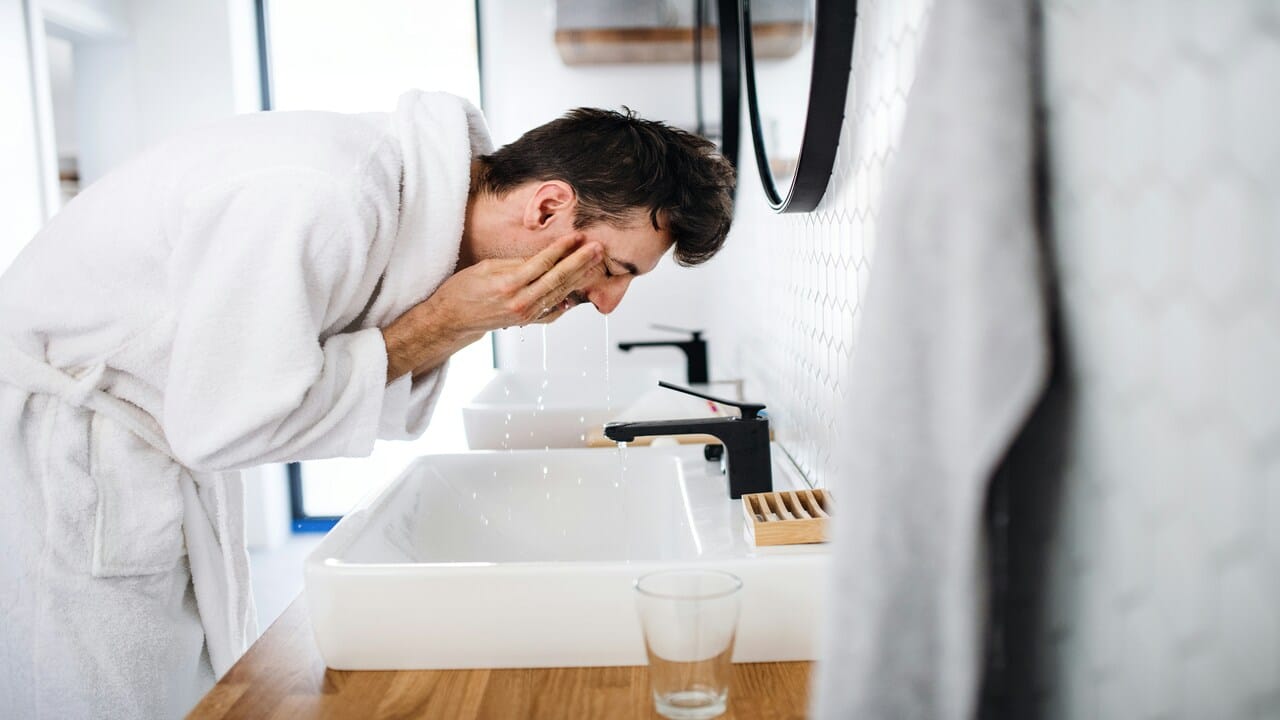 A man splashing water on his face 