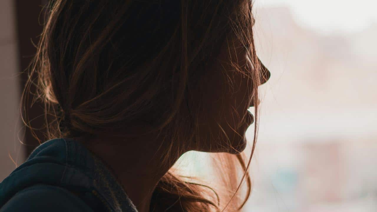 A woman in profile looking out a window.