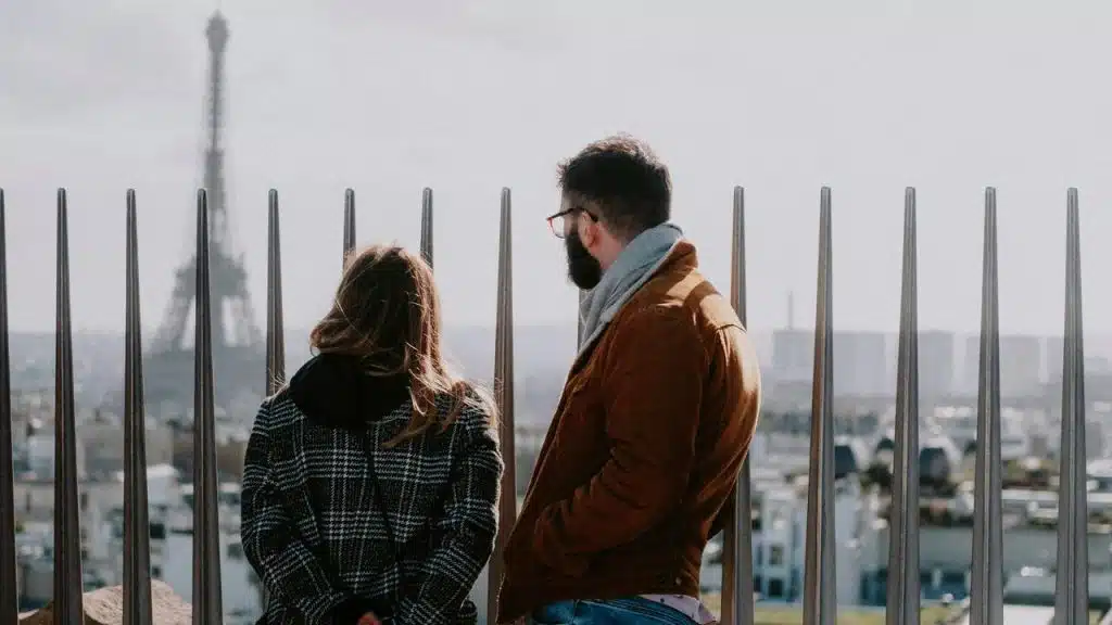 A couple standing and looking out over a city skyline.