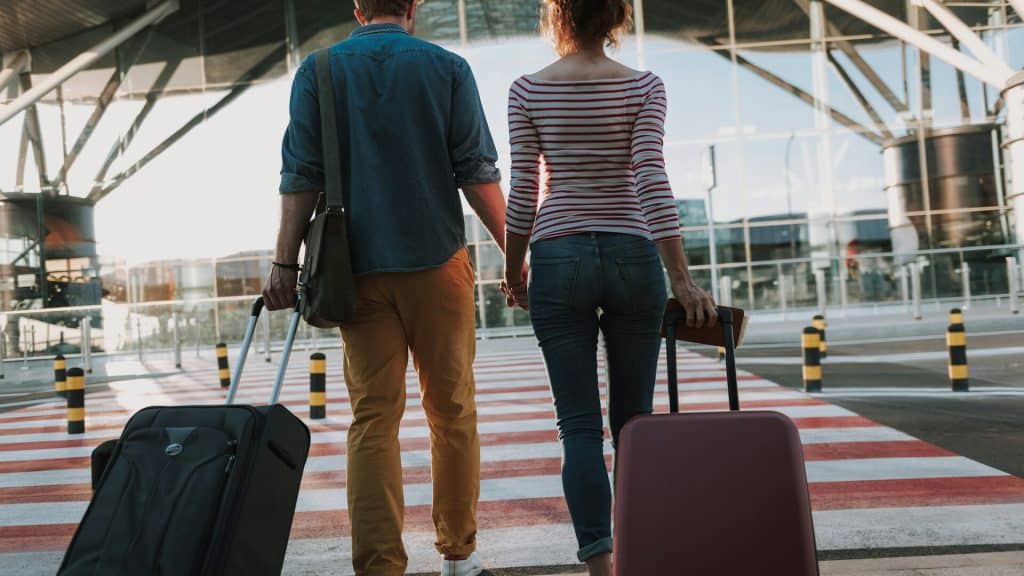 A couple carrying their luggages.