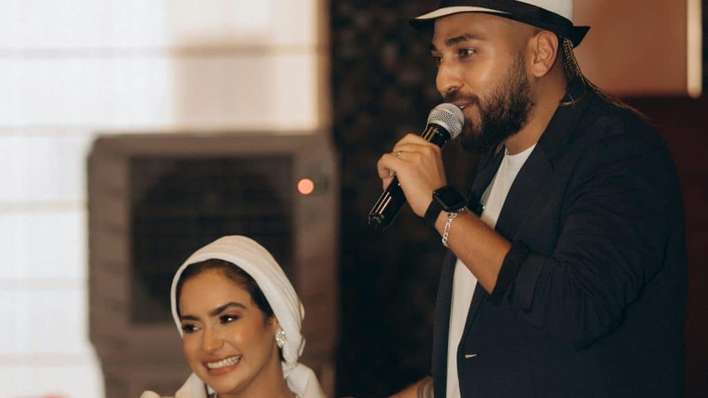 A man standing next to a woman holding a microphone.
