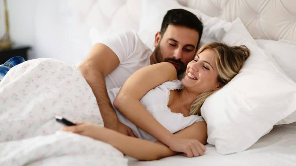 Happy attractive couple enjoying their time in bed.