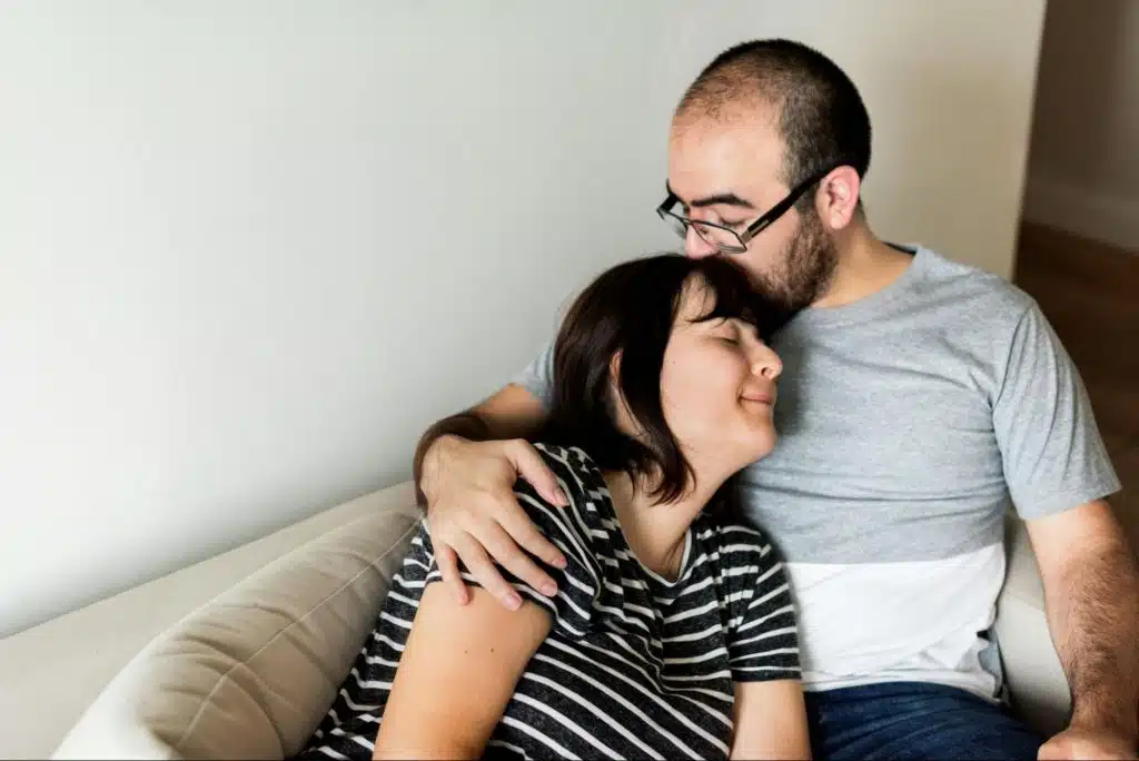 A man kissing a woman’s head