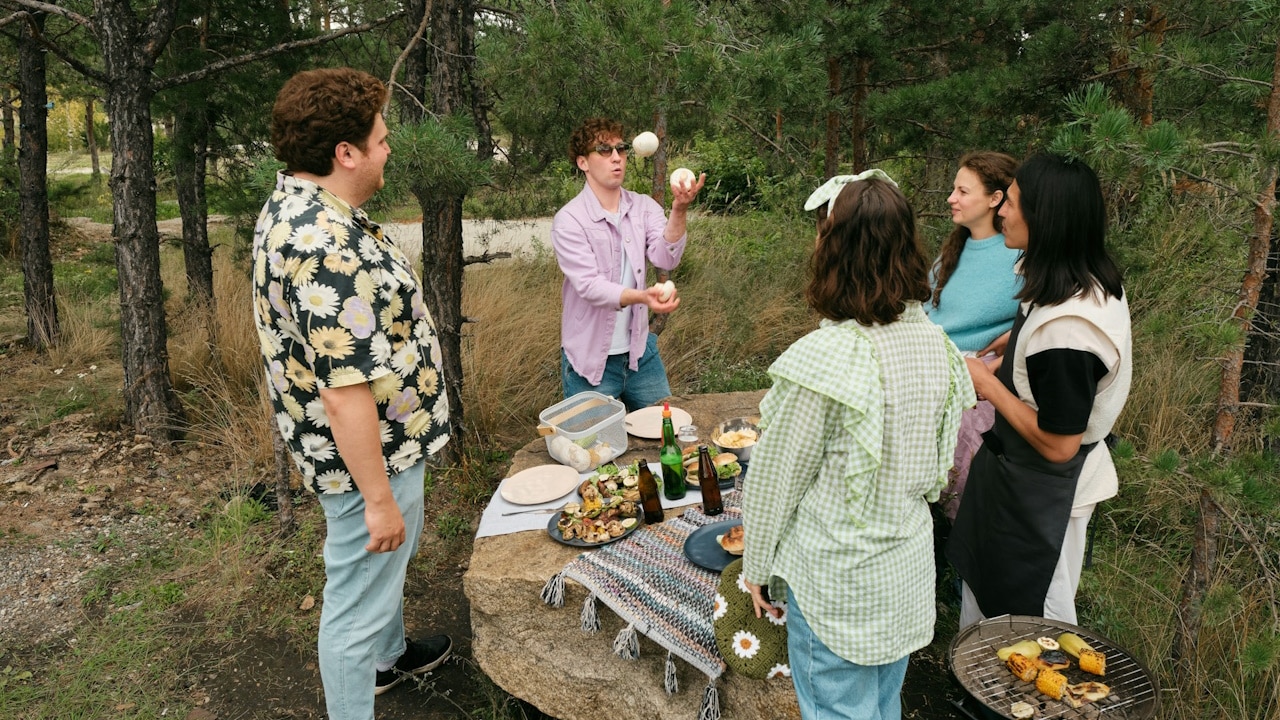A group of people standing around a picnic table.