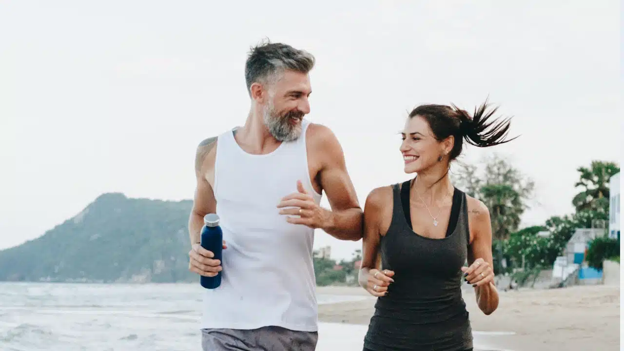 A couple jogging at a beach.