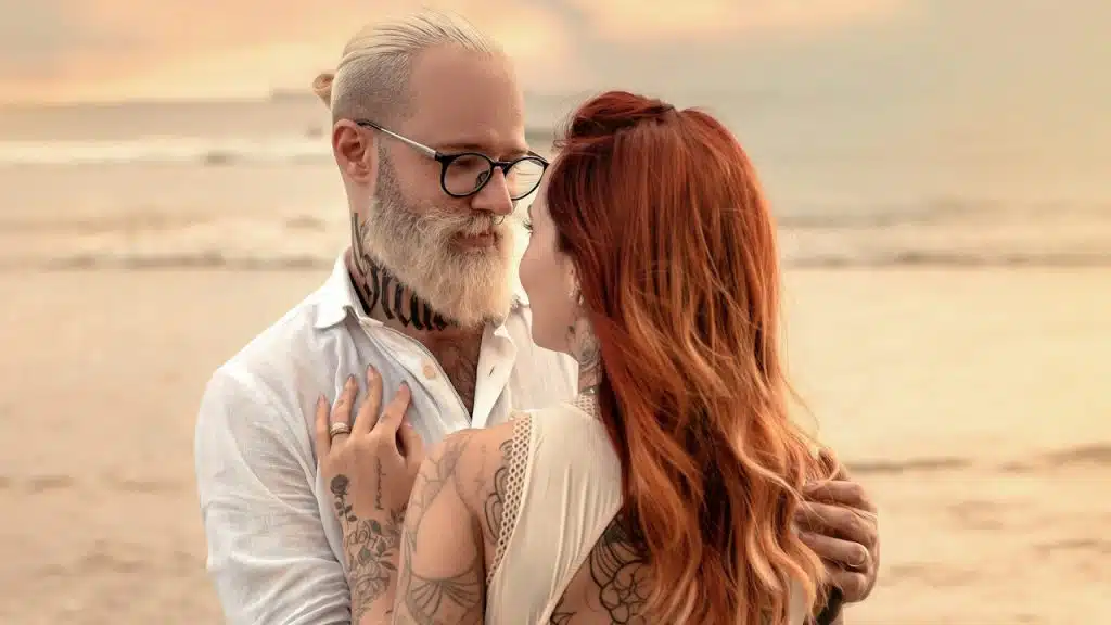 A man and woman hugging on a beach.