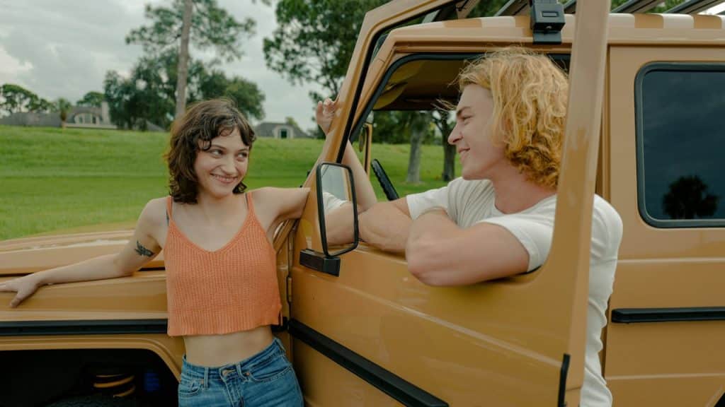 A woman standing next to a man in the back of a truck.