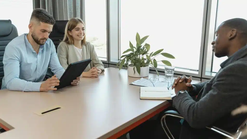 A man being interviewed by two people in an office.