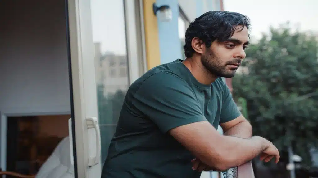 A man looking sad on the balcony