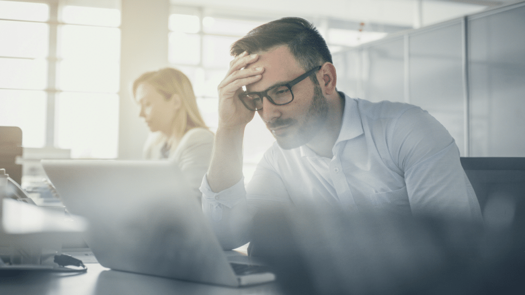A man looking stressed at work