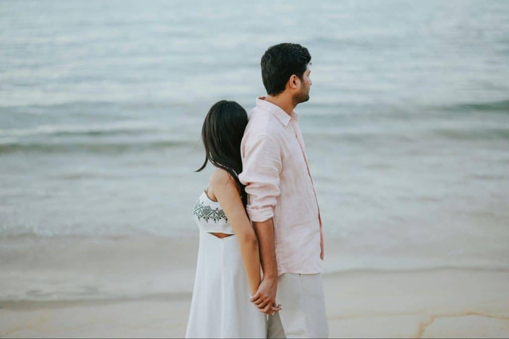 A man and woman standing back to back