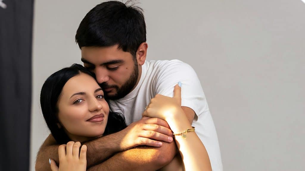 A loving couple embraces each other affectionately.