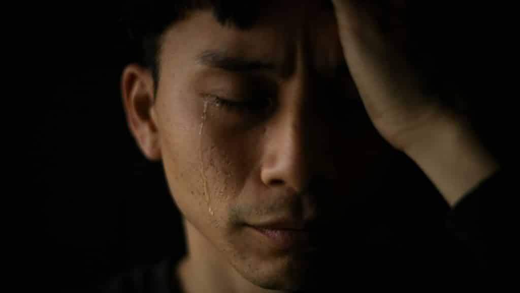 A close-up of a man crying.