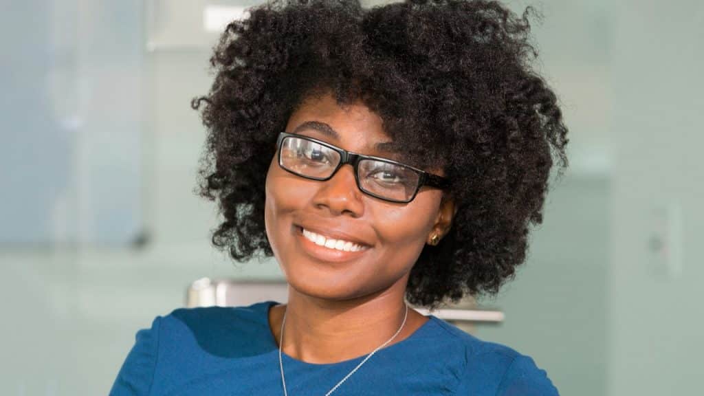 A woman wearing glasses is smiling.