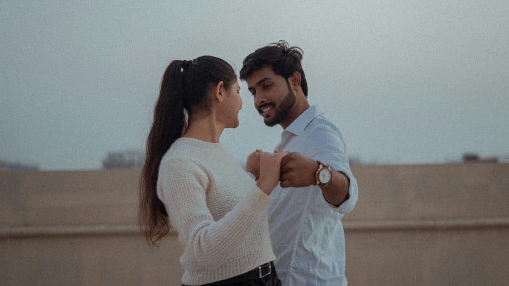 A man and a woman standing next to each other on a rooftop.