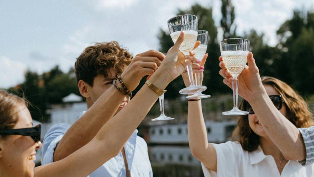 A group of friends raising champagne glasses outdoors.