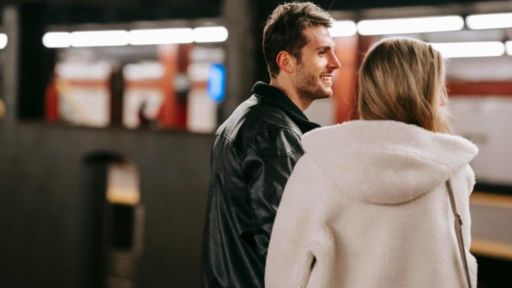 A couple talking at a subway platform.