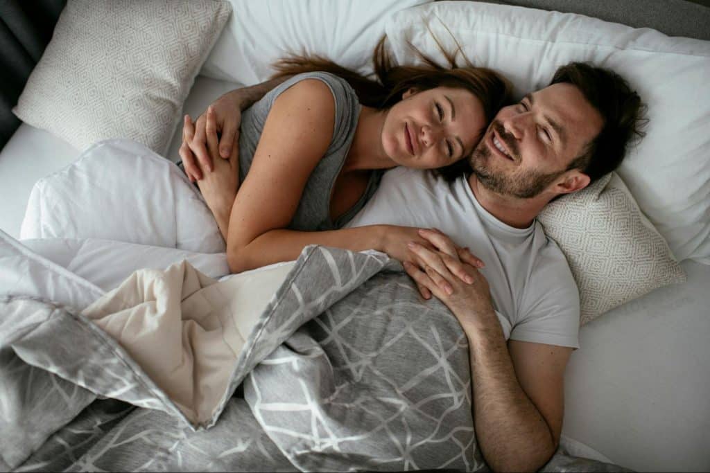 A man and woman at the bed