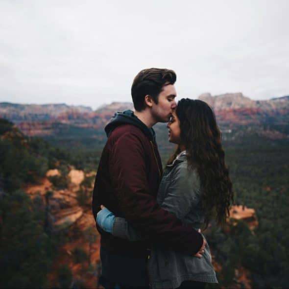 A man kissing a woman’s forehead