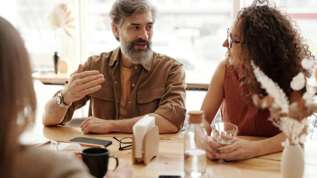 A group of people having a discussion at a café table.