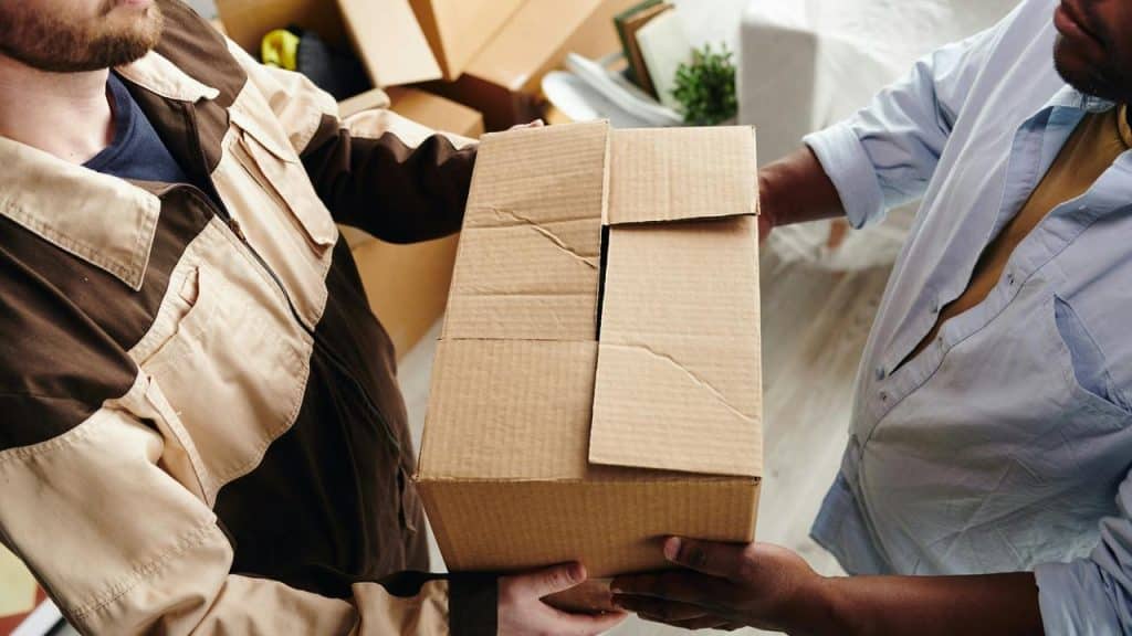 A person handing a cardboard box to another person.
