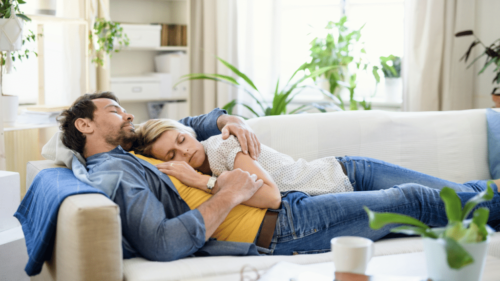 A couple sleeping together on the couch