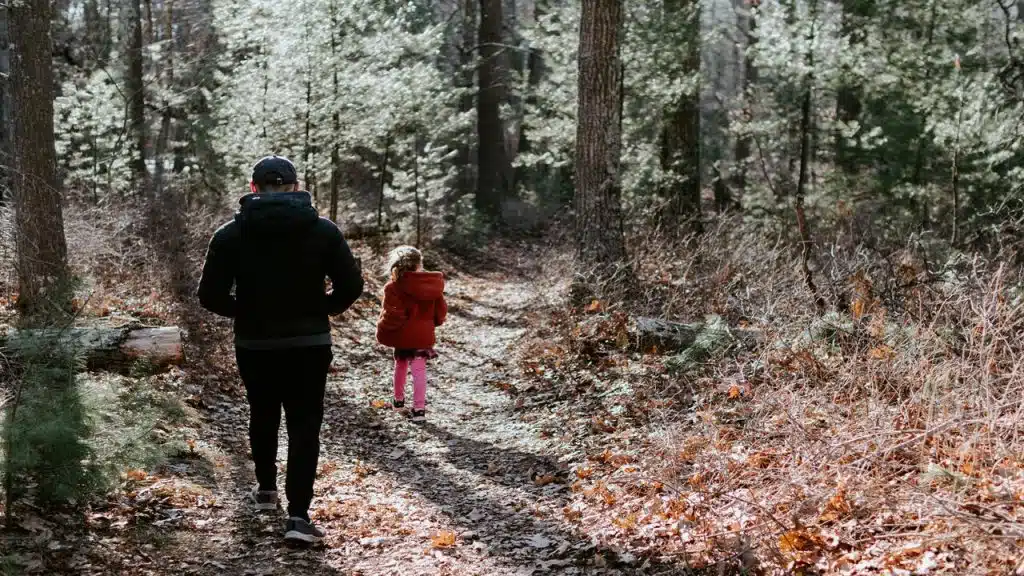 Father and daughter walking in the woods
