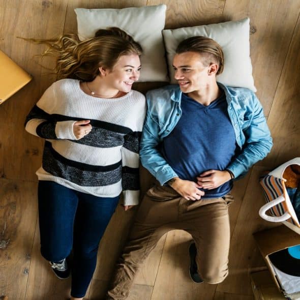 A couple laying on the floor while moving houses