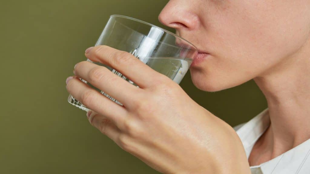 A woman drinking water indoors