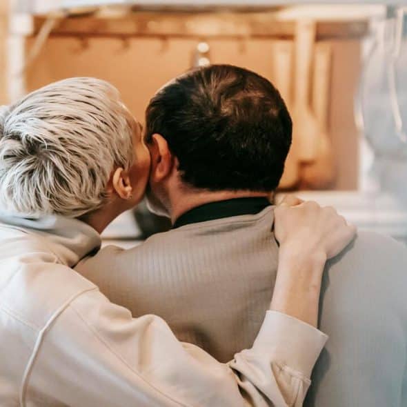 A woman kissing her husband on the cheek