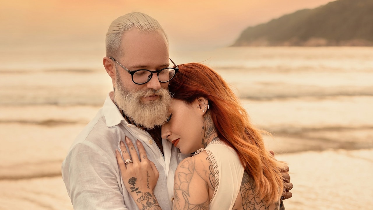 A man and a woman hugging each other on a beach.