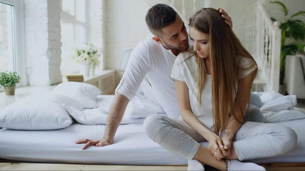A man trying to comfort a sad woman