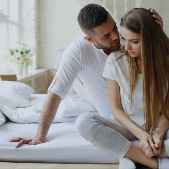 A man trying to comfort a sad woman