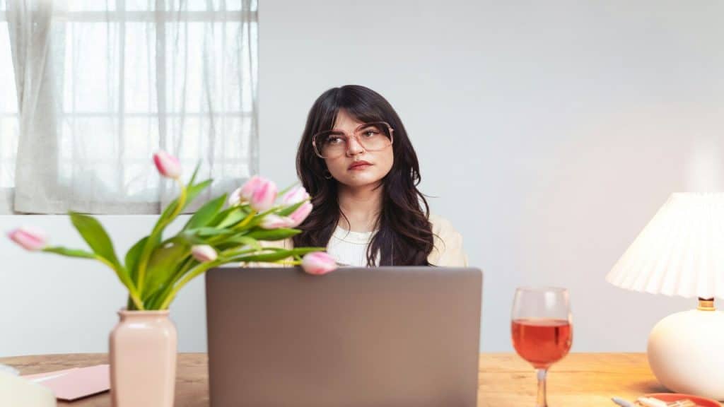 Woman with laptop and glass of wine