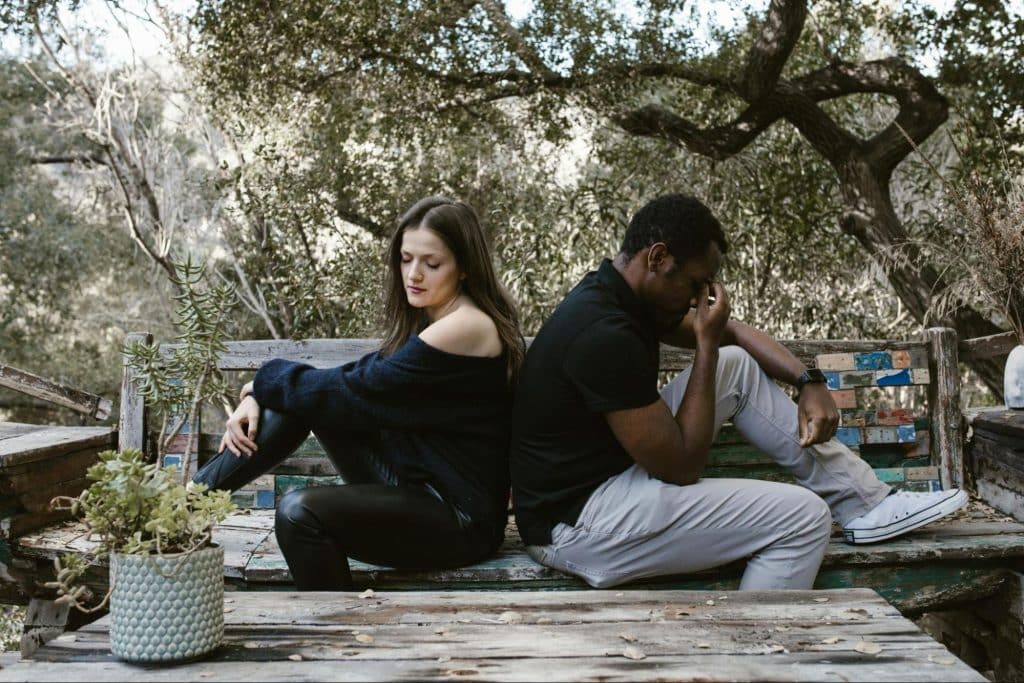 A man and woman back to back from each other